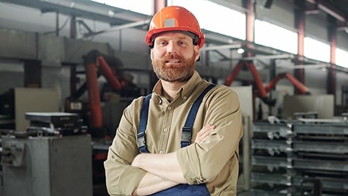 Man with Beard Standing in Industrial Plant